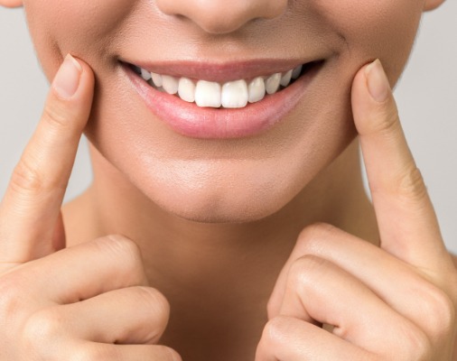 Patient pointing to smile after soft tissue laser dentistry