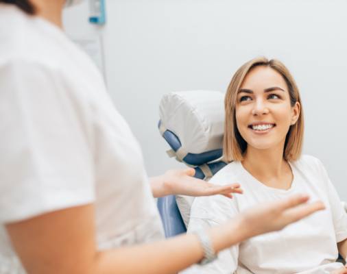 Woman in dental office talking to dentist