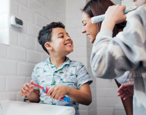 Mother looking at child's smile after dental sealant placement