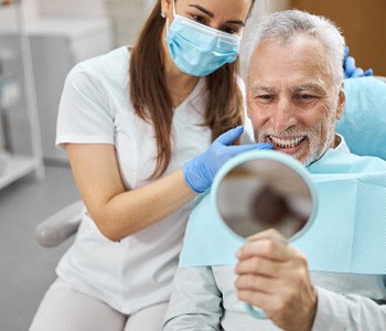 older man smiling after getting dental implants