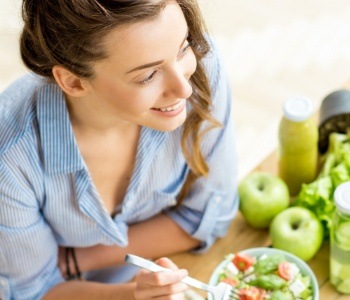 Woman eating a salad and apple