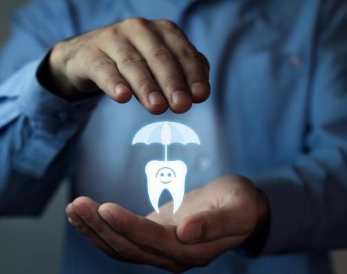 Hands holding an animated tooth under an umbrella