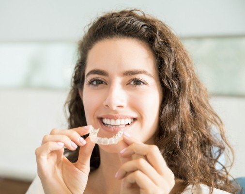 Woman placing Invisalign tray