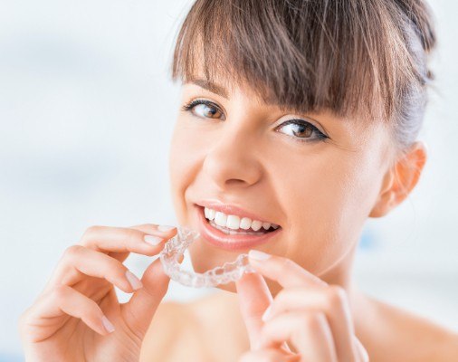 Woman placing an Invisalign tray