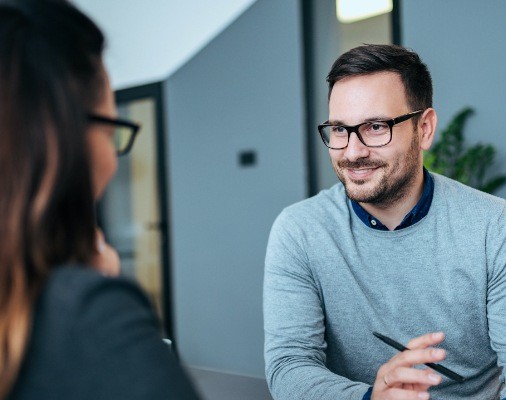 Man discussing the cost of Invisalign with dental team member