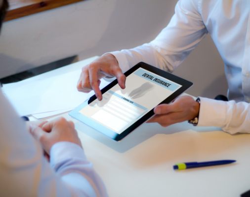 Dentist and dental team patient reviewing dental insurance claims