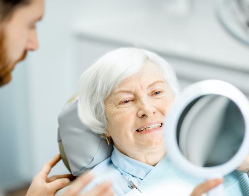 Woman looking at smile after periodontal therapy