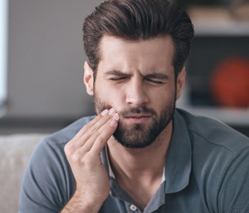A bearded man experiencing a toothache