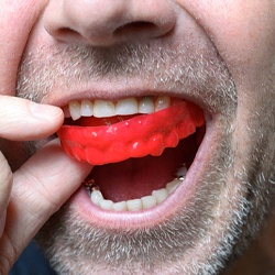 Close up of man removing red mouthguard