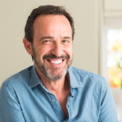 Man smiling in blue collared shirt