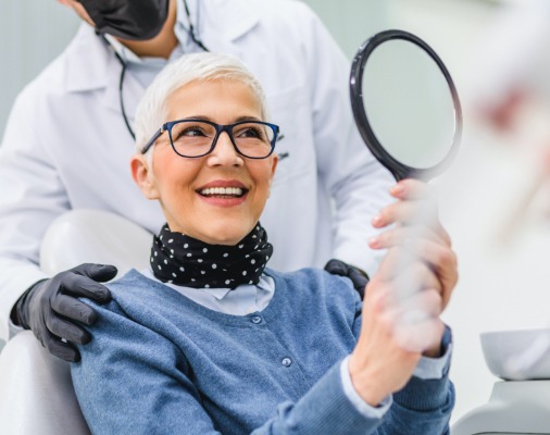 Woman looking at smile after oral cancer screening