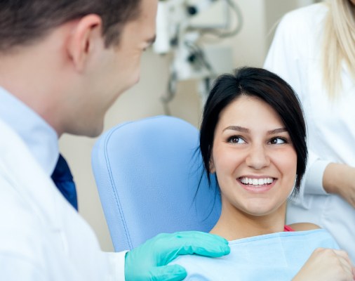 Woman in dental chair smiling at dentist