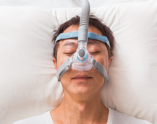 Man sleeping with CPAP mask in place