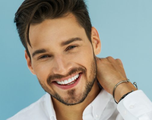 Man showing off flawless smile after porcelain veneer treatment