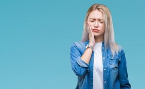 a woman holding her cheek in pain