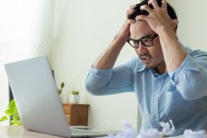 stressed person trying to find out if they have a dental emergency by searching on their computer