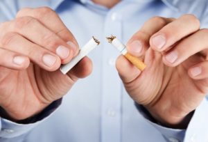 close up of person breaking cigarette in their hands 