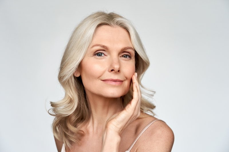 an older woman touching her face gently after getting Botox from a dentist in Mt. Holly