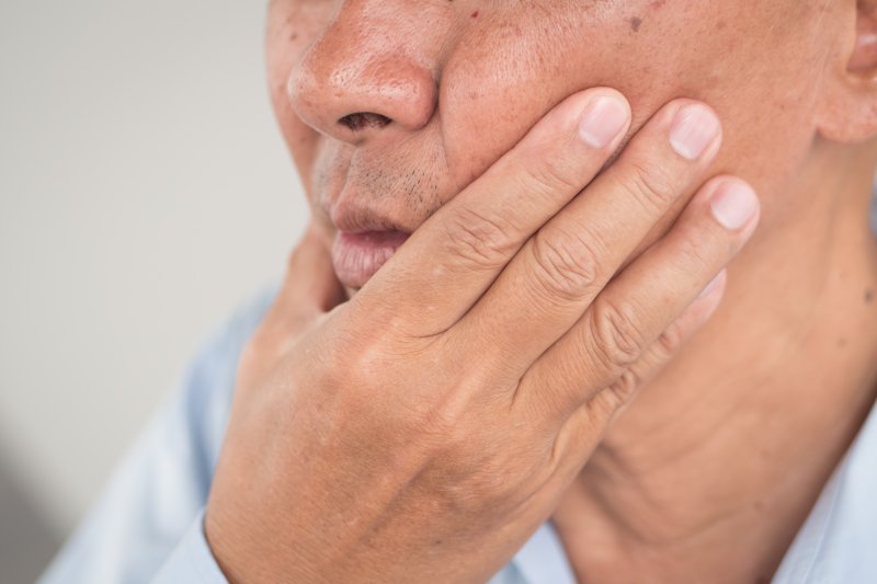 Man experiencing pain from denture