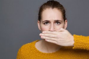 Woman with oral bacteria covering her mouth