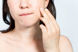 woman holding jaw in pain